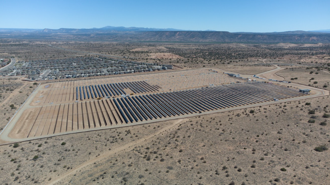 Aerial view of ASG community solar farm in New Mexico — rows of completed solar panels stretching across the desert